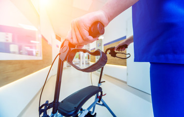 Patient on rollator with hand brakes moving in hospital