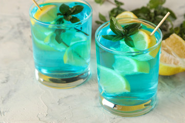 Cocktail blue lagoon in a cocktail glass with lemon and mint on a bright table in the bar. cool summer cocktail