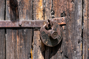 Antique padlock on a wooden door. Metal vintage lock. Rusty old door lock.