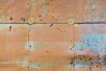 orange paint peeling off old metal strips. Old Metallic patchwork orange. Metal panels are peeling off paint. old metal sheets