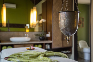 Ayurveda spa treatment copper vessel for shirodhara, oil-dripping treatment setup, no people.
