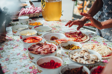 Male chef preparing dough for pizza in outdoor market. Street food.