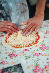 Male chef preparing dough for pizza in outdoor market. Street food.