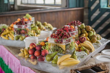 Background Fruit Platter of Strawberries Grapes Blueberries Peaches Apricot Banana Sweet Cherries Pears on Ice.