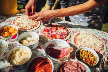 Male chef preparing dough for pizza in outdoor market. Street food.