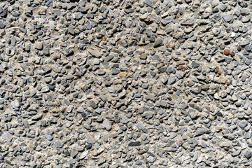 fine gravel road surface. Small stone glued with concrete. Small gravel pavement. Background type view of small rocks on a pavement road.