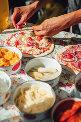 Male chef preparing dough for pizza in outdoor market. Street food.