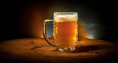 Creative concept. Beer glasses on wooden table at dark toned foggy background.