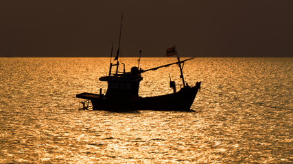 The fisherman boat silhouette on the sea with sunset sky