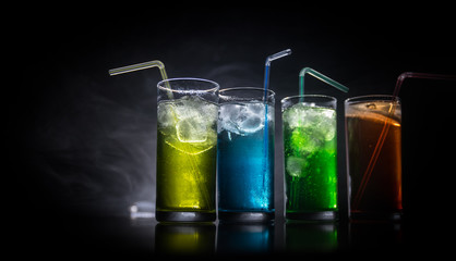 collection of colorful shots with lemon on bar; set of alcohol mini cocktail shooters with lime;