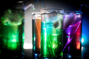 collection of colorful shots with lemon on bar; set of alcohol mini cocktail shooters with lime;