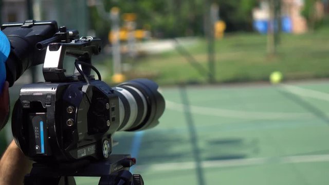 Studio camera. Cameraman changing camera settings focal length, aperture and zoom preparing for shooting. 4K.