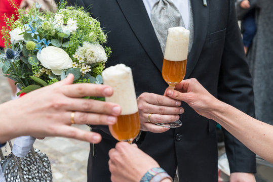 Ein frisch vermähltes Brautpaar bekommt ein Glas Bier zum Anstoßen, Deutschland