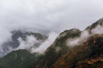 Photo of mountains with trees, smoke