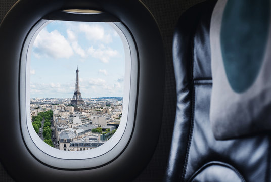 Traveling Paris, France famous landmark and travel destination in Europe. Aerial view Eiffel Tower through airplane window	