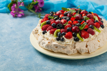 Meringue Pavlova cake with fresh fruit. Front view.