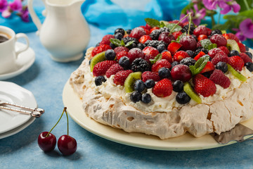 Meringue Pavlova cake with fresh fruit. Front view.