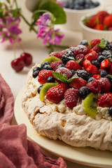 Meringue Pavlova cake with fresh fruit. Front view.