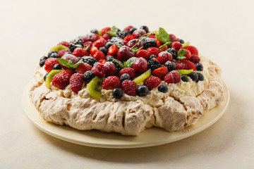 Meringue Pavlova cake with fresh fruit. Front view.