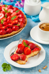 Delicious tart with strawberries on a blue painted background. Front view.