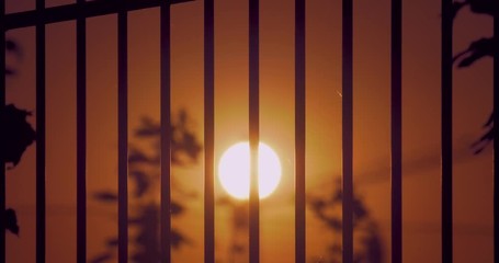 Prison fence lattice against the backdrop of the setting summer sun - Powered by Adobe