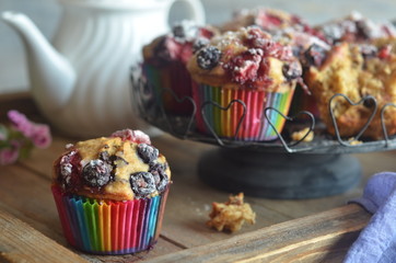 Banana muffins with fruit on a wooden background. White jug in the background