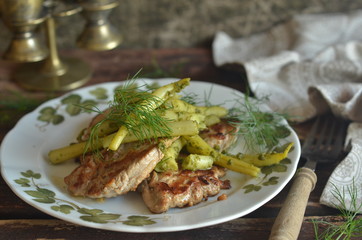Fried tenderloin with yellow beans and dill on a rustic plate