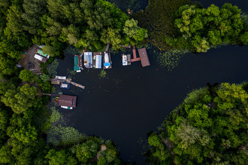 drone views  A look down on a pond in the middle of a forest with boats.