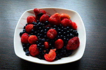 strawberries and blueberries in a plate on the table