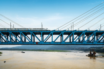 The high-speed train runs at high speed on the railway bridge. The Yangtze River Bridge of Chongqing Railway, China