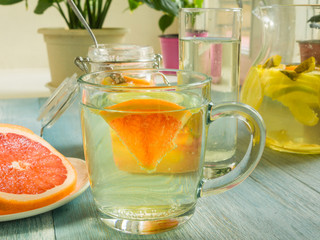 A glass with homemade lemonade from lemon and grapefruit on the table by the window