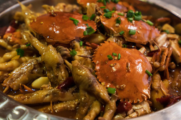 A large bowl of meat crabs and chicken feet