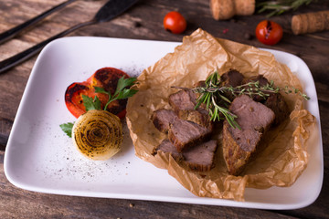 Baked pork and grilled vegetables on white plate