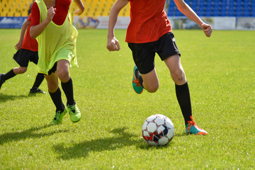 Obraz premium Young football players play football at the stadium