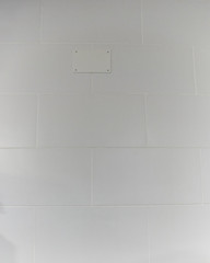 White wall. Big squared rectangle tiles pattern.