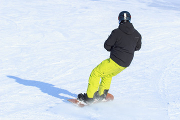 Fototapeta na wymiar one snowboarder snowboarding in winter mountains