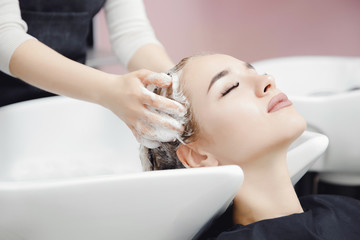 Obraz na płótnie Canvas Concept head massage. Beautiful blond woman getting hair wash in beauty salon