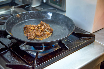 Solid broth sofrito for paella foundation preparation. Heating in a pan.