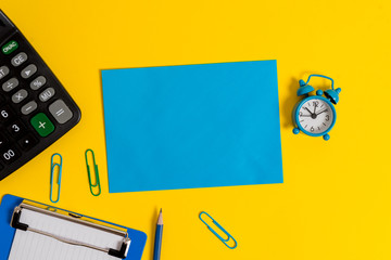 Clipboard sheet clips note calculator pencil alarm clock colored background