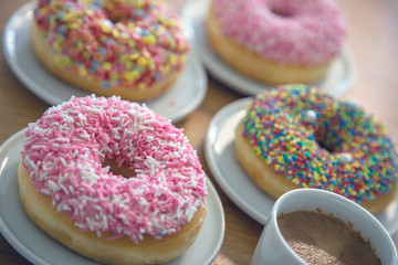 Doughnuts and coffee cup on wood. Close up view