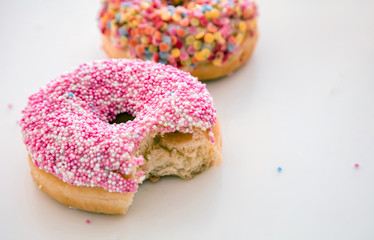 Doughnuts pink and pastel on white color background.