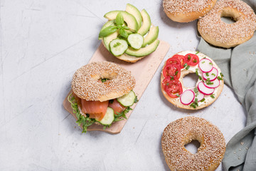 Bagel sandwiches with avocado, salmon, egg and vegetables, healthy snack, top view