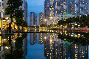 Twilight scene of modern city with buildings and reflection on lake in Hanoi, Vietnam