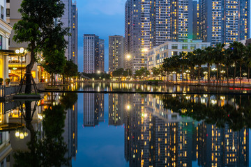 Fototapeta premium Twilight scene of modern city with buildings and reflection on lake in Hanoi, Vietnam
