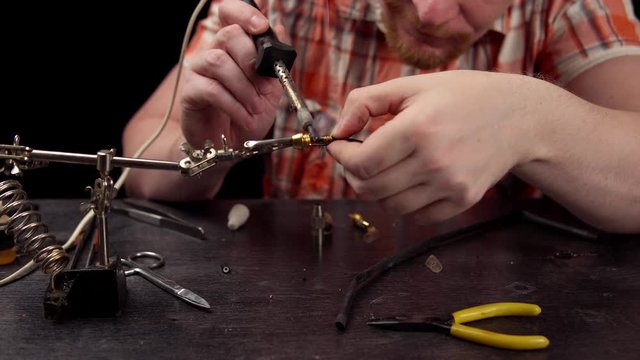 Process of replacing cable for audio cinch connector. Muscled electrician solder wire with rosin soldering iron to male jack rca.