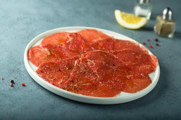 Homemade beef carpaccio with salt and pepper