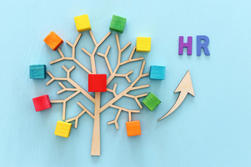 Business image of wooden tree with colorful cubes over blue table, human resources and management concept