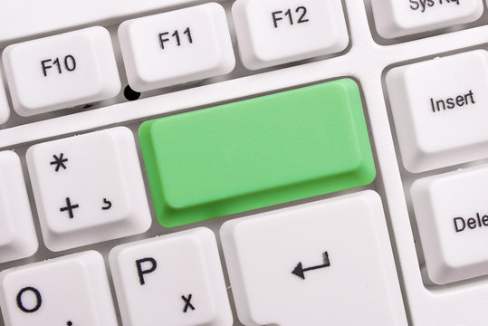 White pc keyboard with empty note paper above white background key copy space