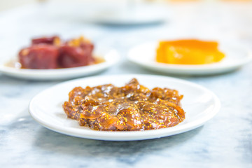 Sweet delicious and tasty fig jam or fig marmalade dessert in plate on white table background. Various fruit desserts or jams 