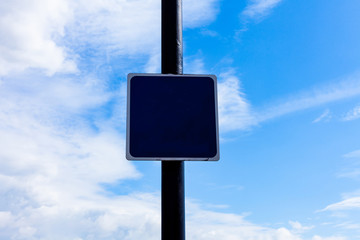 Road sign on the crossroads with blue cloudy sky in the background.